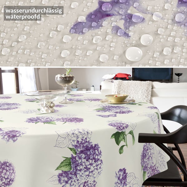 Runde Tischdecke mit Hortensienmuster und wasserundurchlässiger Oberfläche, dargestellt durch Wassertropfen in der Nahaufnahme.