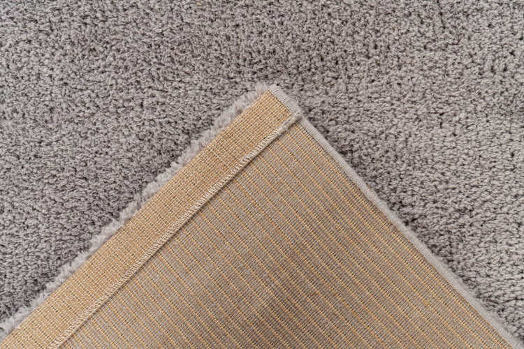 Teppich mit hochflorigem Textilobermaterial und stabiler gewebter Unterseite in Nahaufnahme.