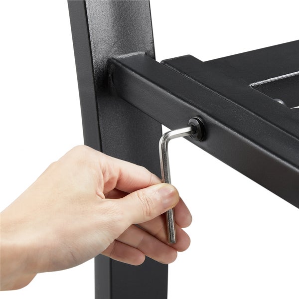 Anziehen einer Schraube mit einem Innensechskantschlüssel an einem schwarzen Metallmöbel