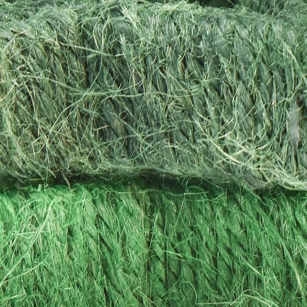 Nahaufnahme von zwei aufgewickelten Paketschnüren aus Naturfaser mit faseriger Struktur