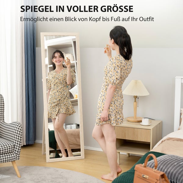 Ganzkörperspiegel im Schlafzimmer mit einer Frau, die ihr Outfit betrachtet