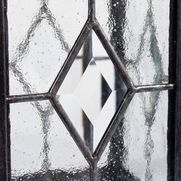 Detailaufnahme eines Fensters mit strukturierter Glasoberfläche und Rautenmuster