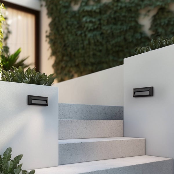 Schwarze LED-Außenwandleuchten montiert an einer hellen Mauer neben einer Steintreppe im Außenbereich.