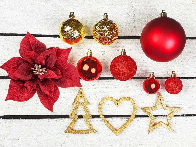 Weihnachtsdekoration bestehend aus Christbaumkugeln, einem Weihnachtsstern sowie glitzernden Anhängern in Baum, Herz und Sternform.