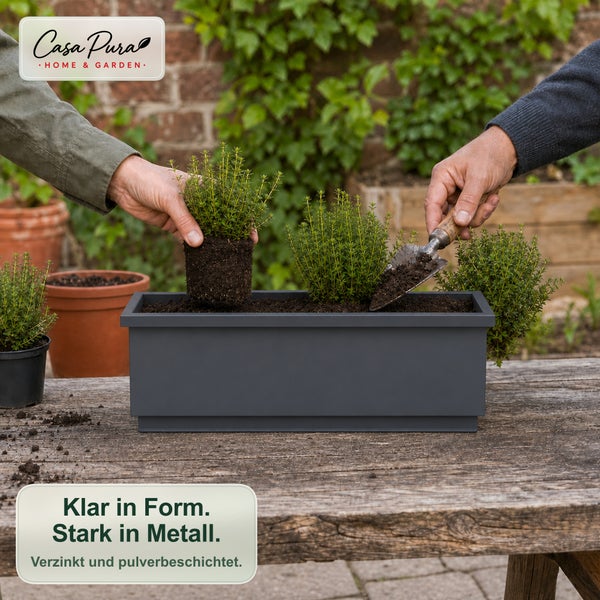 Personen pflanzen Kräuter in einen rechteckigen Metall Blumenkasten auf einem Holztisch im Garten