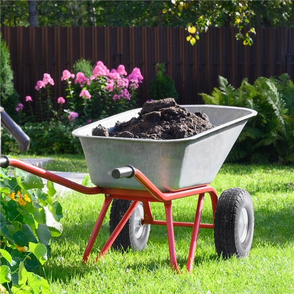 Schubkarre gefüllt mit Erde im Garten