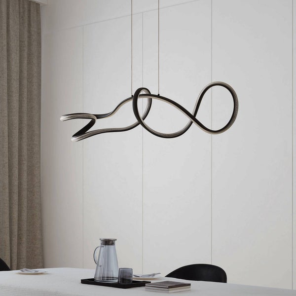 Moderne LED-Pendelleuchte in geschwungenem Wellendesign über einem hellen Esstisch in einem minimalistischen Raum.