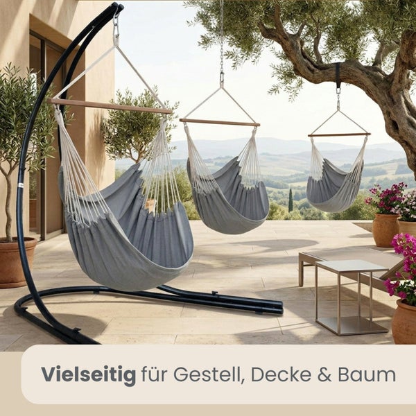 Drei Hängesessel aus Stoff auf einer Terrasse, befestigt an einem Gestell, der Decke und einem Baum.