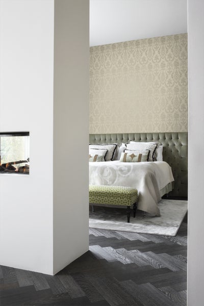 Schlafzimmer mit Bett, gepolstertem Kopfteil, Tapete und Bank