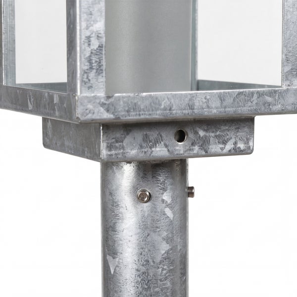 Nahaufnahme der Verbindung zwischen einem eckigen Laternenkopf und einem Pfosten aus verzinktem Metall.
