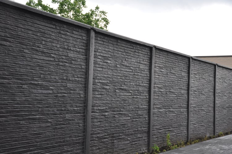 Lange graue Steinmauer zur Grundstücksbegrenzung