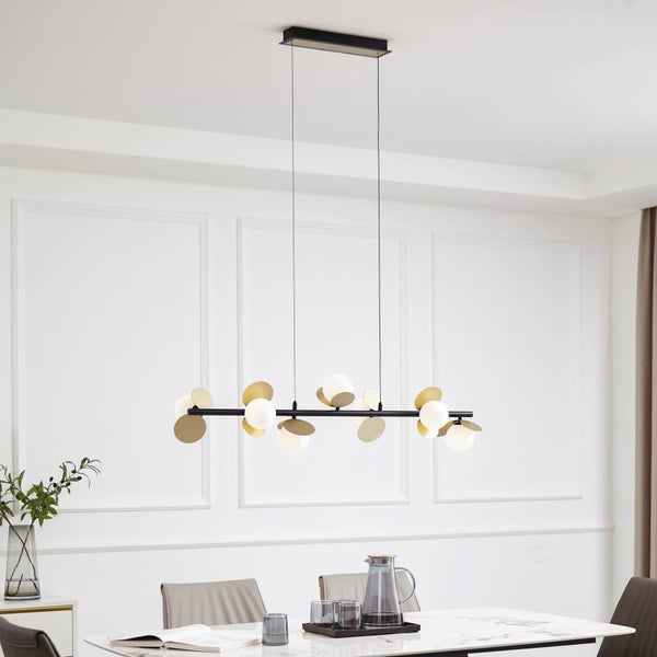 Moderne Pendelleuchte mit schwarzem Metallstab, weißen Glaskugeln und goldfarbenen Dekorscheiben über einem Esstisch in einem hellen Raum.