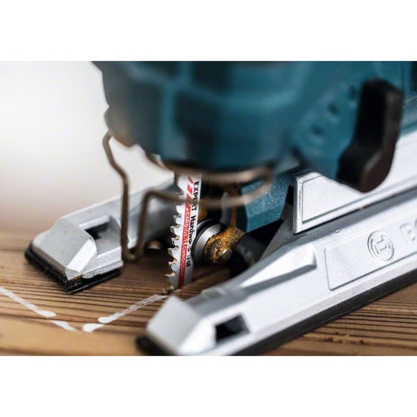 Nahaufnahme einer Stichsäge mit Metallsägeblatt auf einem Holzbalken