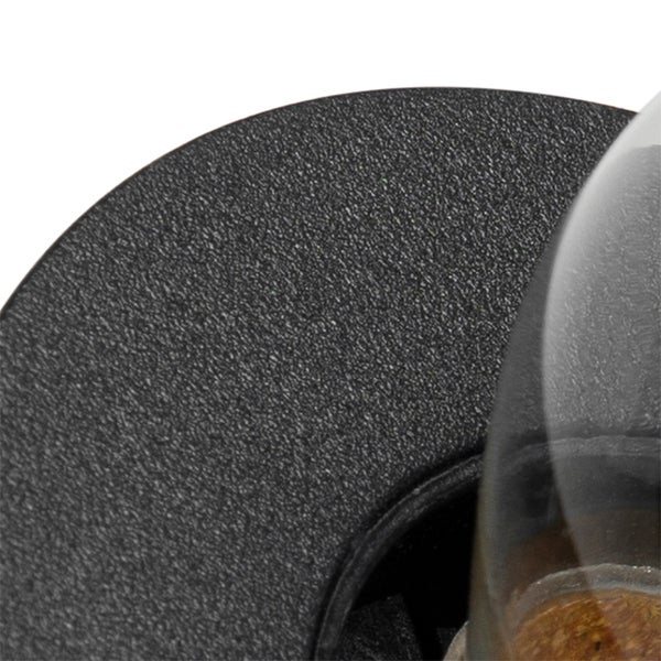 Detailaufnahme eines schwarzen Sockels mit Sanduhr