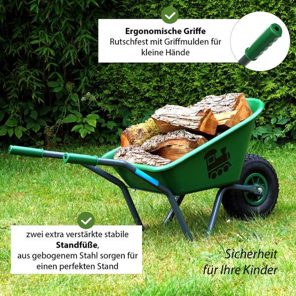 Grüne Kinderschubkarre aus Stahl mit Holzladung im Garten