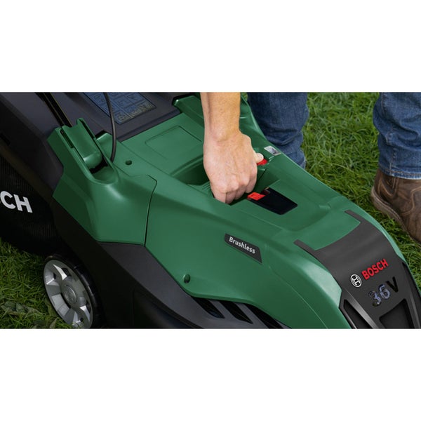 Platzsparende Aufbewahrung eines zusammengeklappten Bosch Rasenmähers mit bürstenlosem Motor unter einem Holztisch in einem organisierten Bereich.