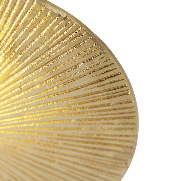 Nahaufnahme einer goldenen Dekorplatte mit radialem Muster.