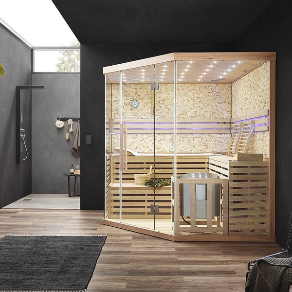 Moderne Ecksauna mit Glaselementen und Holzausstattung, genutzt von einem Paar in einem modernen Wohnraum mit Steinwandoptik innen.