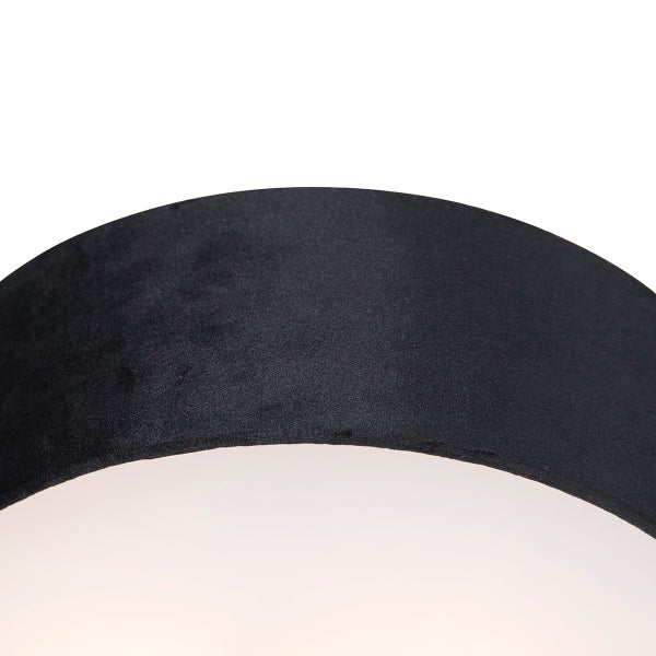 Detailaufnahme eines schwarzen Lampenschirms aus Samt mit weißer Innenseite.