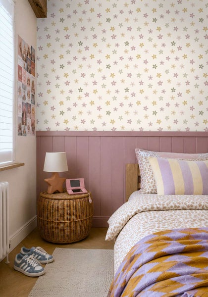 Ein Kinderzimmer mit blumiger Tapete, einer hölzernen Wandverkleidung und einem gemütlichen Bett mit gemustertem Bettbezug.