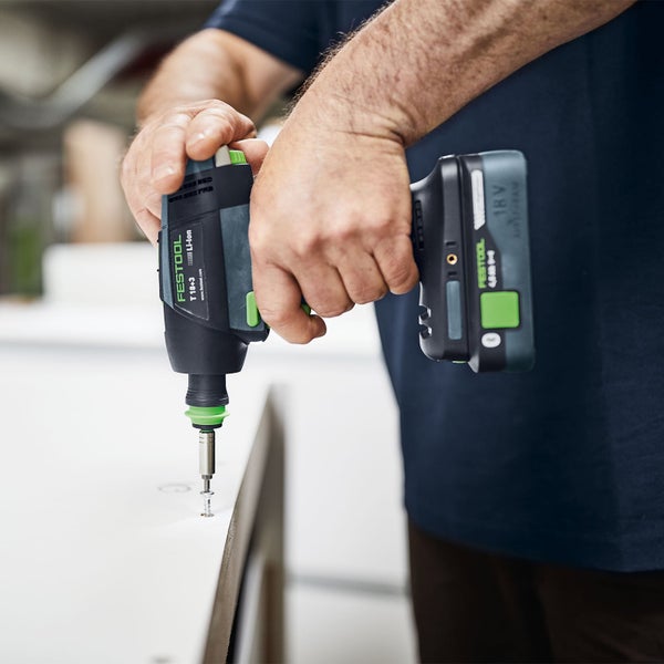 Mann schraubt mit einem Festool Akku-Bohrschrauber eine Schraube in ein Werkstück