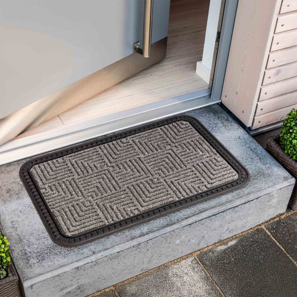 Fußmatte mit geometrischem Muster vor einer offenen Tür
