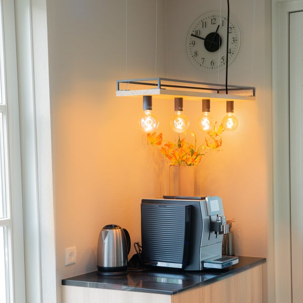 Moderne Küchenszene mit Pendelleuchte, Kaffeemaschine und Wasserkocher