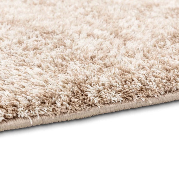 Detailansicht eines beige-weißen Hochflor-Teppichs Shaggy mit weichem Flor und umkettelter Kante.