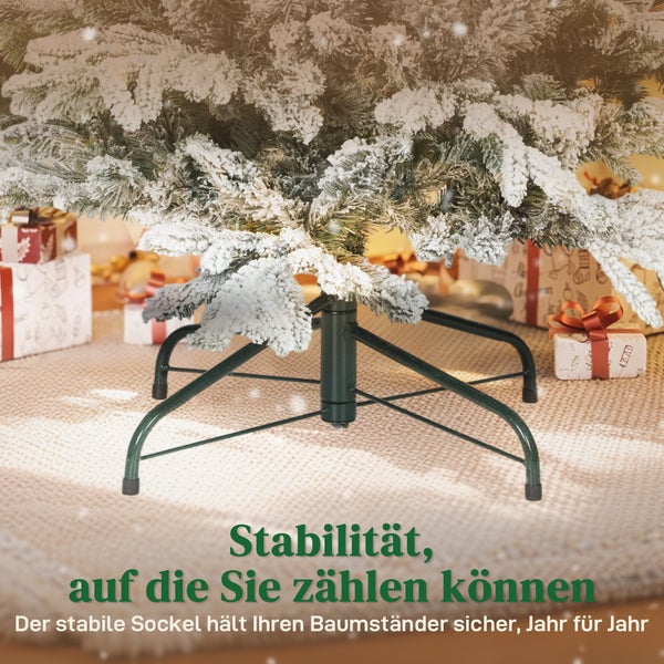 Stabiler Christbaumständer aus Metall unter einem künstlichen, verschneiten Weihnachtsbaum mit Geschenken im Hintergrund.