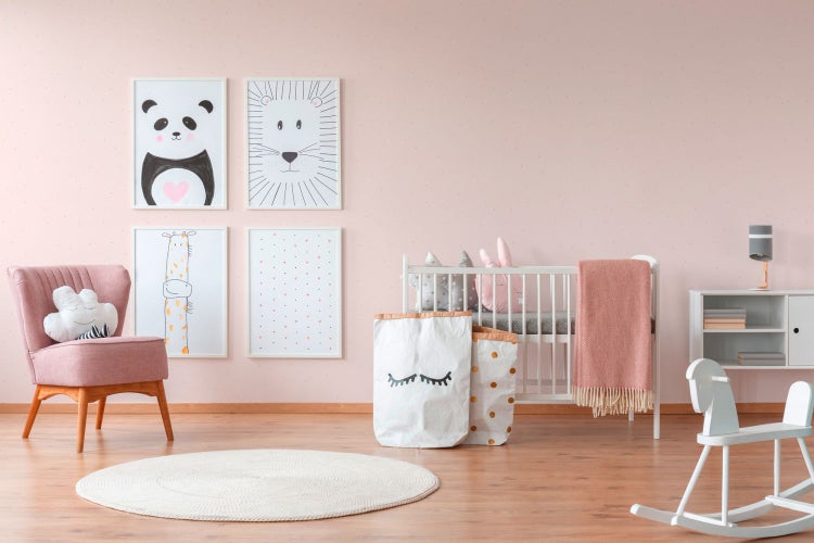 Kinderzimmer mit Kinderbett, Sessel, Teppich und Wanddekorationen für ein gemütliches Ambiente