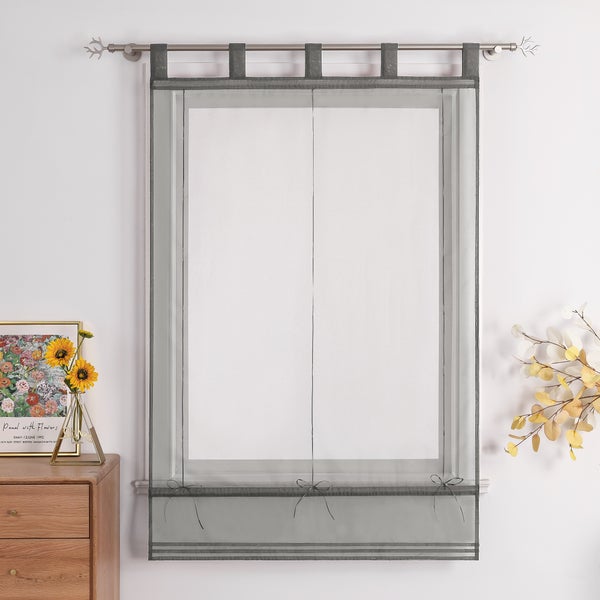 Dekoratives Fenster mit grauem Rollo und Gardinenstange