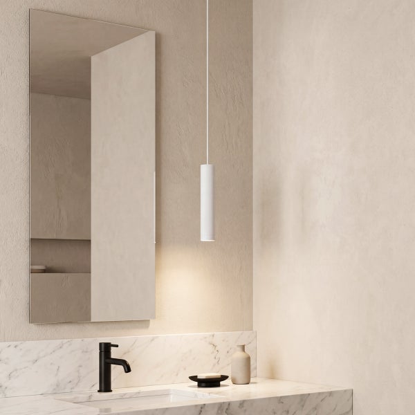 Modernes Badezimmer mit Waschtisch aus Marmor, Wasserhahn, Wandspiegel und hängender Pendelleuchte.