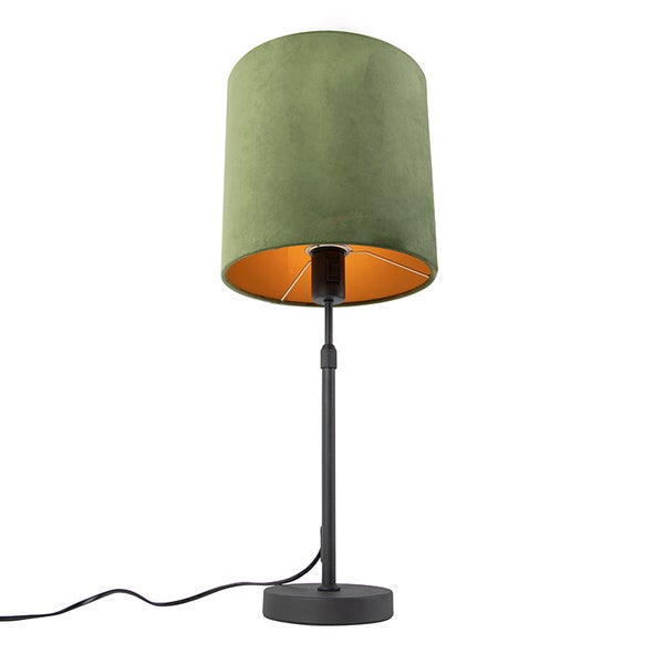 Tischleuchte mit grünem Samtschirm, goldener Innenseite und schwarzem Metallfuß.