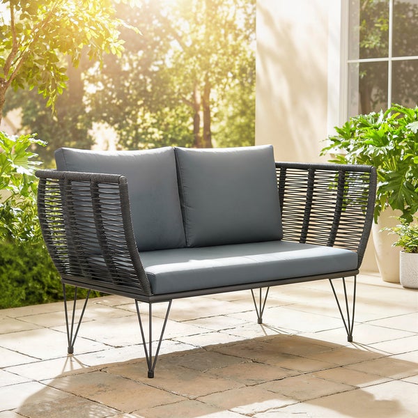 Modernes 2-Sitzer Gartensofa mit dunklem Seilgeflecht, Metallbeinen und grauen Polstern auf einer hellen Terrasse.