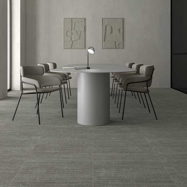 Moderner Konferenzraum mit strukturierten Fliesen auf dem Boden und einem ovalen Tisch mit Sitzgelegenheiten in minimalistischem Design.