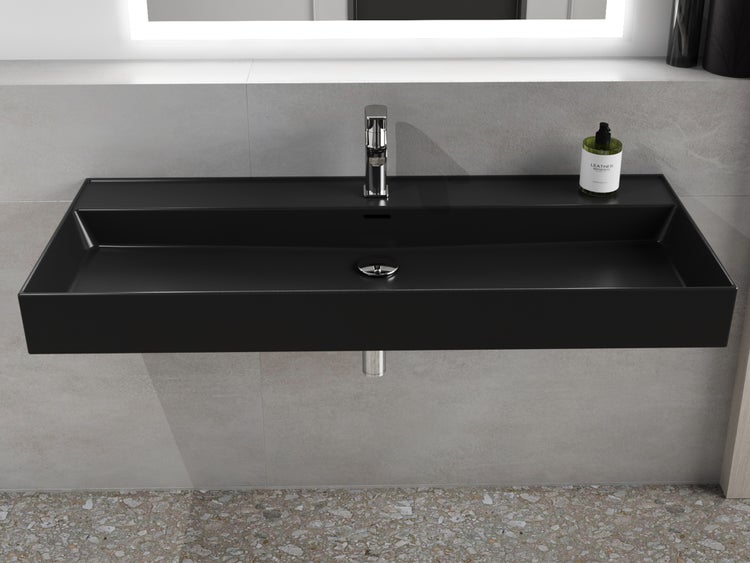 Schwarzes Aufsatzwaschbecken mit Armatur und Seifenspender im Badezimmer