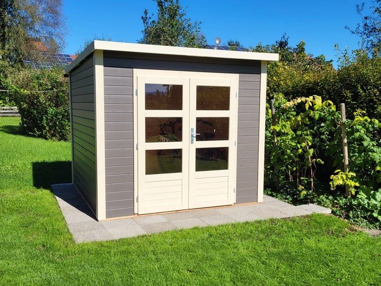 Modernes Gartenhaus aus Holz in Anthrazit mit cremefarbenen Doppeltüren und Flachdach auf einer gepflasterten Fläche im Garten.