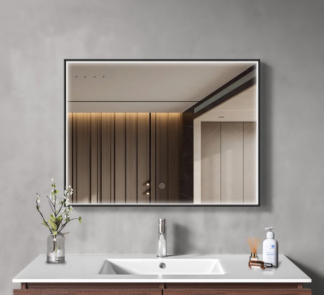 Rechteckiger Badezimmerspiegel mit LED Beleuchtung und Touch Sensor an einer grauen Wand über einem Waschbecken mit Armatur.