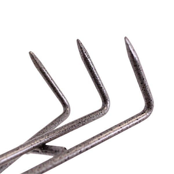 Detailansicht der drei spitzen Metallzinken eines Handgrubbers für die Gartenarbeit.