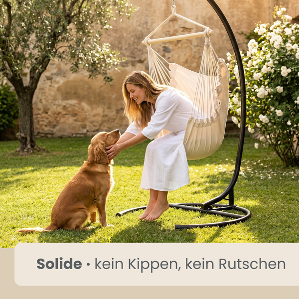Hängesessel aus Stoff mit Holzstab an einem stabilen, bogenförmigen Metallgestell in einem hellen Garten mit einer Frau und einem Hund.