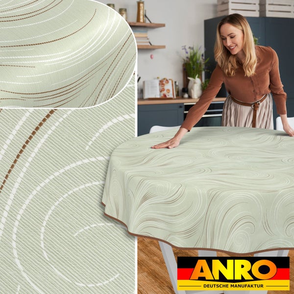 Runder Tisch mit ANRO Tischdecke und wirbelndem Muster im Küchendekor. ANRO Deutsche Manufaktur Logo.