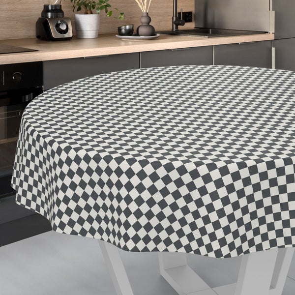 Runde Tischdecke mit kleinkariertem Muster auf einem Esstisch in einer modernen, aufgeräumten Küche mit Holzarbeitsplatte.