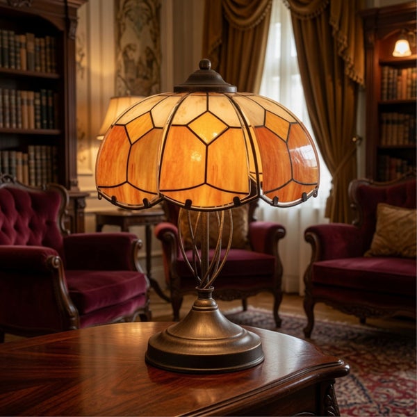 Tischleuchte im Tiffany Stil mit strukturiertem Glasschirm auf hölzernem Tisch in klassischem Wohnzimmer mit Sesseln und Bücherregalen.
