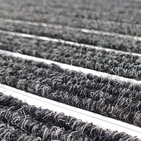 Nahaufnahme eines grauen Sauberlaufstreifens mit Aluminiumprofil