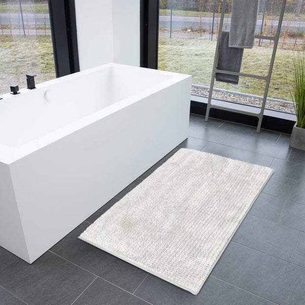 Badezimmer mit Badewanne und Badteppich