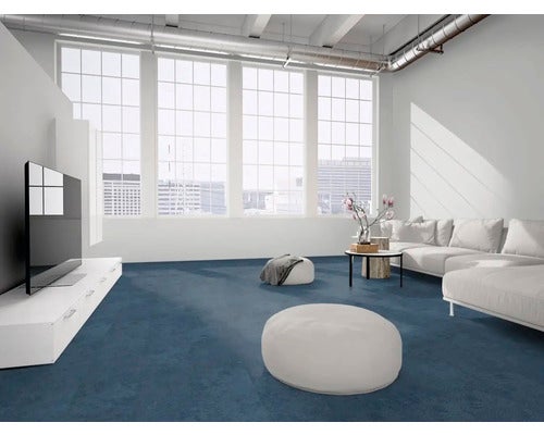 Ein modernes, helles Wohnzimmer mit einem durchgehenden blauen Teppichboden, einem weißen Sofa und großen Fenstern im Industriestil.