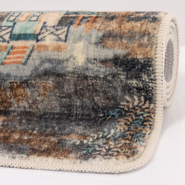 Gerollter Teppich mit abstraktem Muster in Blau und Beige sowie geketteltem Rand.