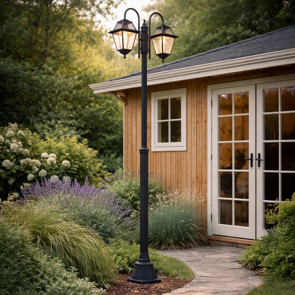 Schwarzer zweiflammiger Kandelaber mit klassischen Laternen in einem Garten neben einem Gartenhaus aus Holz und einem Steinweg.