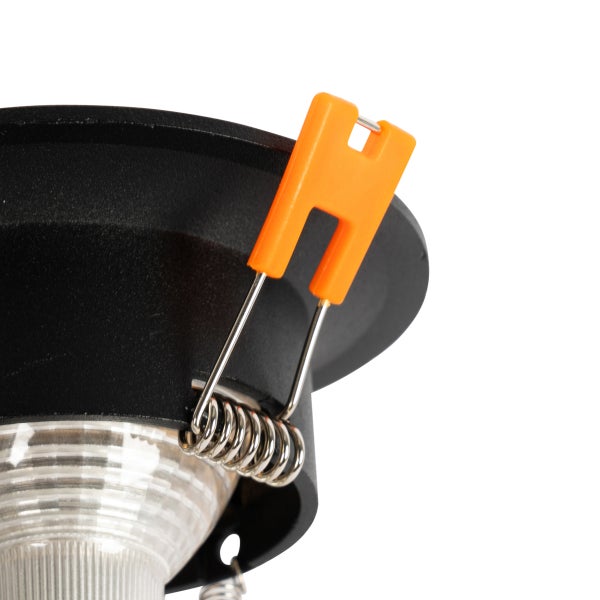 Nahaufnahme der Montagefeder an einem schwarzen LED-Einbaustrahler mit orangefarbenem Clip.