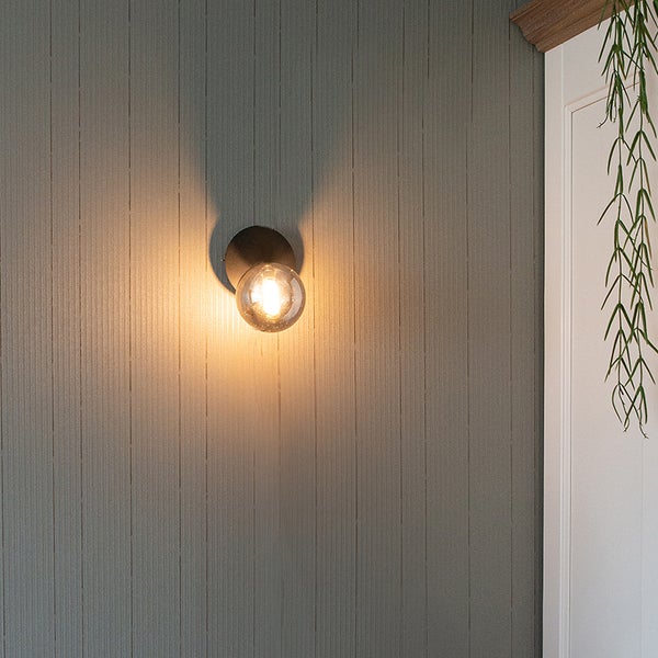 Wandleuchte mit Glaskugel leuchtet an der Wand